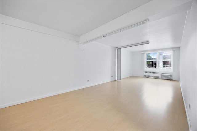 142-05 Roosevelt Ave Unit 331, Flushing, NY 11354 - empty room with radiator heating unit, wood finished floors, and baseboards