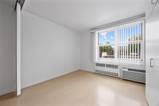 142-05 Roosevelt Ave Unit 331, Flushing, NY 11354 - unfurnished room with radiator heating unit, wood finished floors, and baseboards