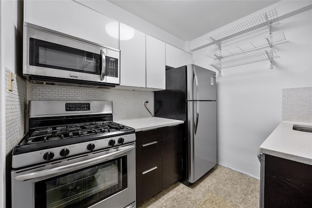 142-05 Roosevelt Ave Unit 331, Flushing, NY 11354 - kitchen featuring stainless steel appliances, backsplash, white cabinets, light stone counters, and baseboards
