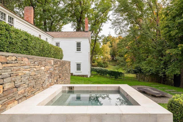 view of swimming pool featuring a hot tub