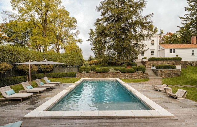 swimming pool with a patio area and fence