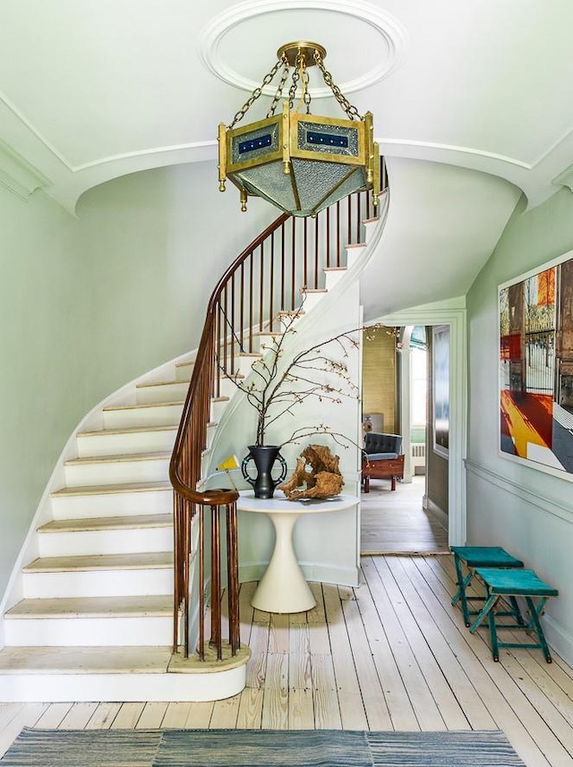 stairway featuring hardwood / wood-style floors and vaulted ceiling
