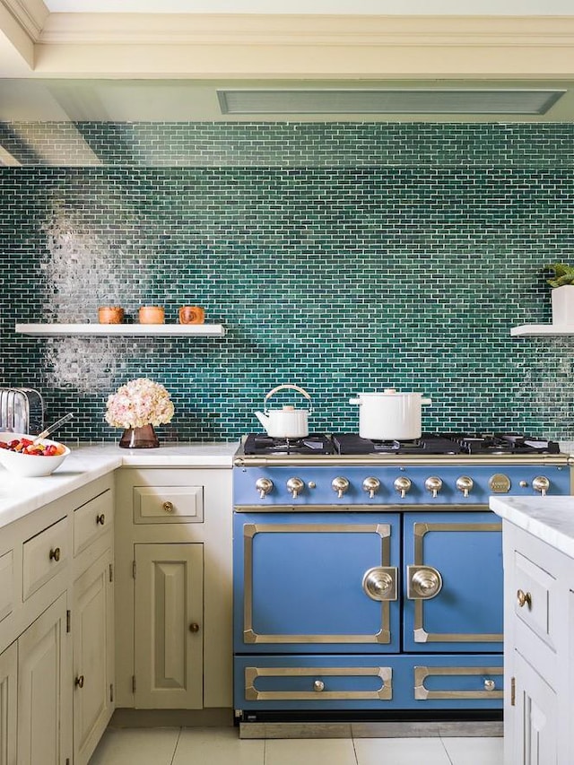 kitchen with decorative backsplash, gas stove, light tile patterned floors, and open shelves