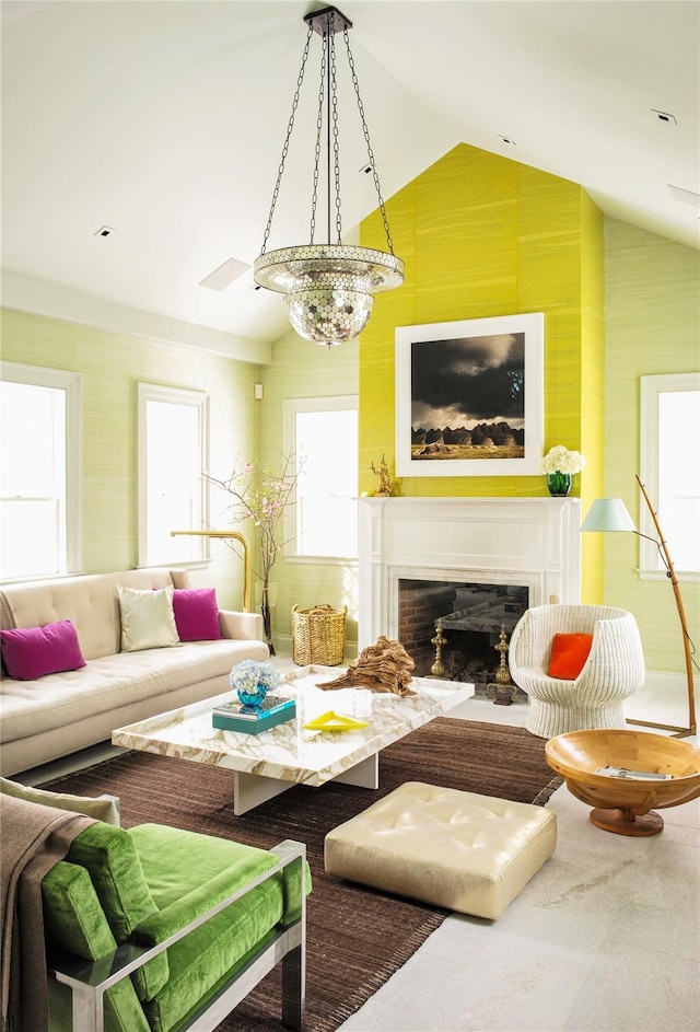 living area with vaulted ceiling and a glass covered fireplace