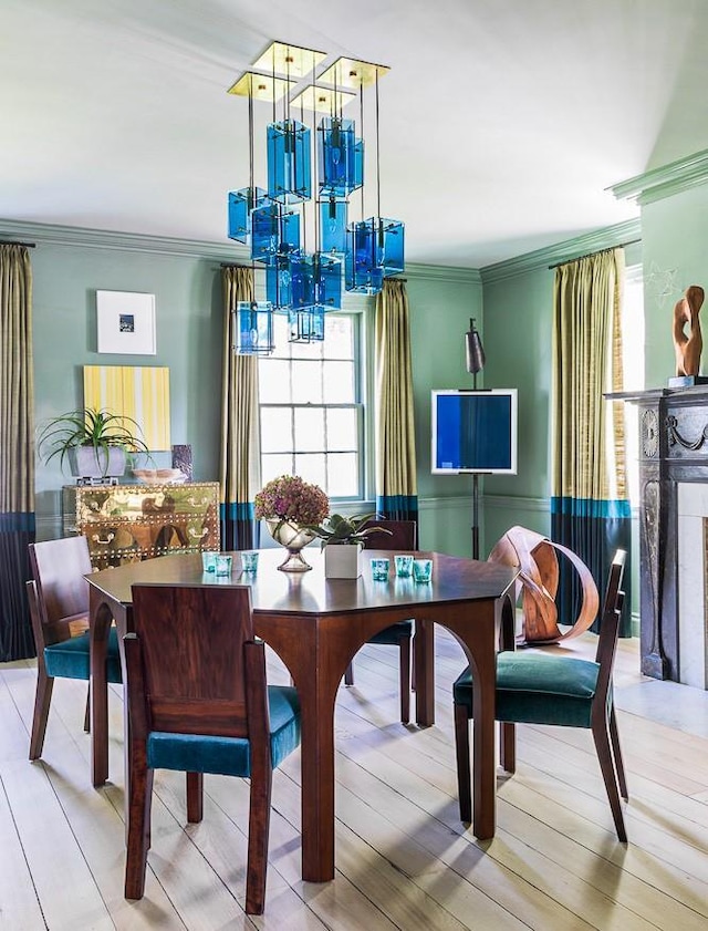 dining room featuring healthy amount of natural light, ornamental molding, a chandelier, and wood finished floors
