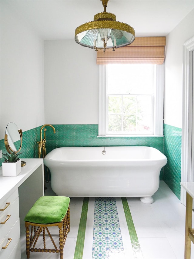 full bathroom with tile walls, a freestanding tub, and wainscoting