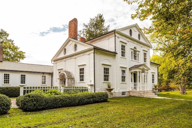 view of front of home featuring a chimney and a front lawn