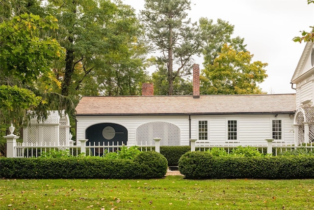 view of front of house with a chimney and a front lawn