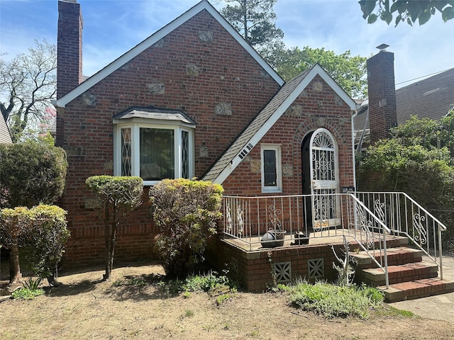 view of front of property featuring brick siding and a chimney