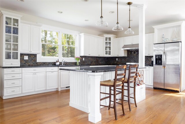 1145 Bay Haven Ln, Southold, NY 11971 - kitchen with stainless steel refrigerator with ice dispenser, under cabinet range hood, a center island, light wood-style flooring, and recessed lighting