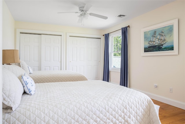 1145 Bay Haven Ln, Southold, NY 11971 - bedroom featuring multiple closets, baseboards, wood finished floors, and a ceiling fan