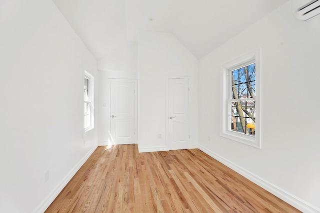 3780 Willett Ave, Bronx, NY 10467 - empty room with light wood-type flooring, healthy amount of natural light, baseboards, lofted ceiling, and a wall mounted AC