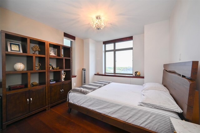 bedroom with dark wood-type flooring and a chandelier