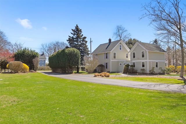 25105 Main Rd, Orient, NY 11957 - view of side of property with a lawn, a chimney, and driveway