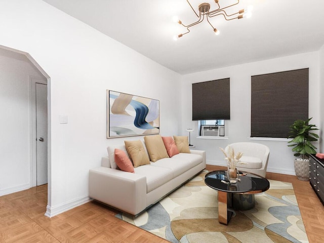 living area with a chandelier, baseboards, and arched walkways