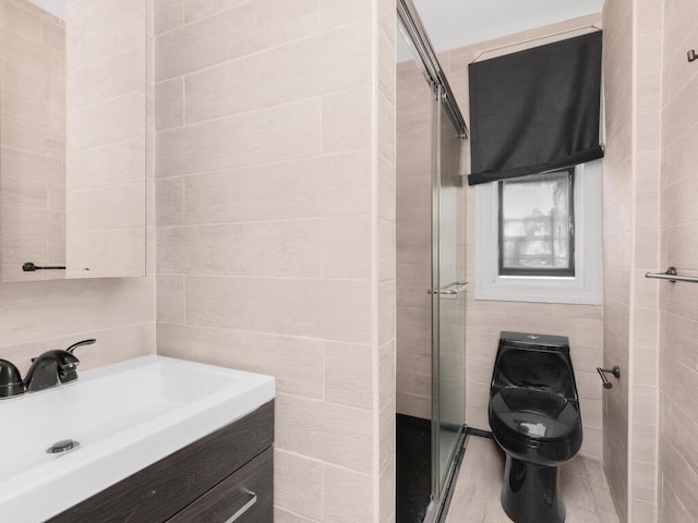 full bathroom with tile walls, vanity, a shower stall, and toilet