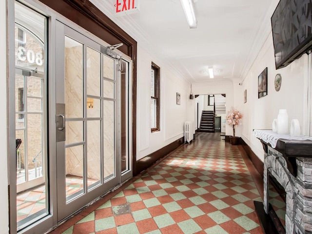 hall featuring radiator, crown molding, stairs, and baseboards