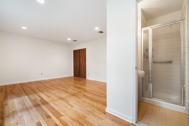 spare room featuring light wood-style floors, recessed lighting, and baseboards