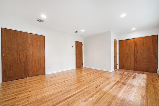 unfurnished bedroom with multiple closets, light wood finished floors, recessed lighting, and baseboards