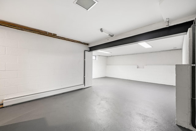 garage featuring a baseboard heating unit and concrete block wall