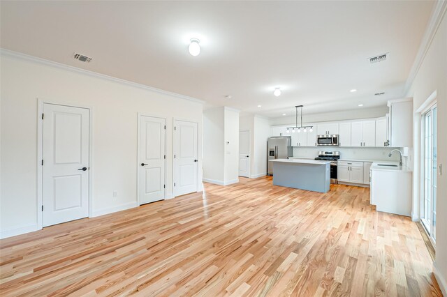 36-A Maple Ave, Port Jefferson Station, NY 11776 - kitchen with appliances with stainless steel finishes, a sink, a center island, light wood finished floors, and light countertops