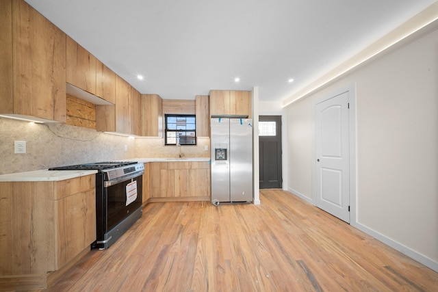 486 Ashford St, Brooklyn, NY 11207 - kitchen with stainless steel refrigerator with ice dispenser, gas stove, a sink, backsplash, and light wood-style flooring