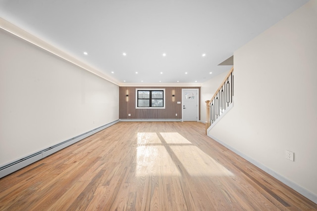 486 Ashford St, Brooklyn, NY 11207 - unfurnished living room featuring light wood finished floors, stairs, baseboards, a baseboard radiator, and recessed lighting