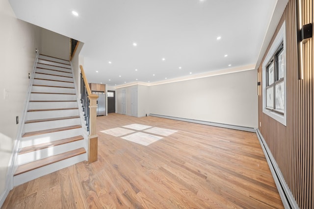 486 Ashford St, Brooklyn, NY 11207 - unfurnished living room featuring a baseboard radiator, stairs, light wood-style floors, recessed lighting, and crown molding