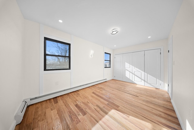 486 Ashford St, Brooklyn, NY 11207 - empty room with healthy amount of natural light, wood finished floors, a baseboard heating unit, and recessed lighting