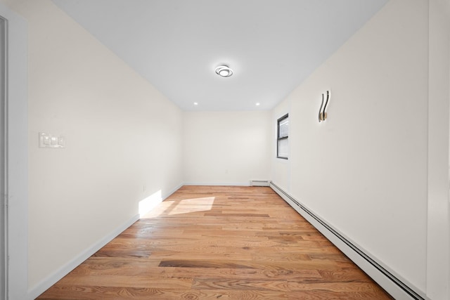 486 Ashford St, Brooklyn, NY 11207 - spare room featuring a baseboard radiator, light wood finished floors, and baseboards