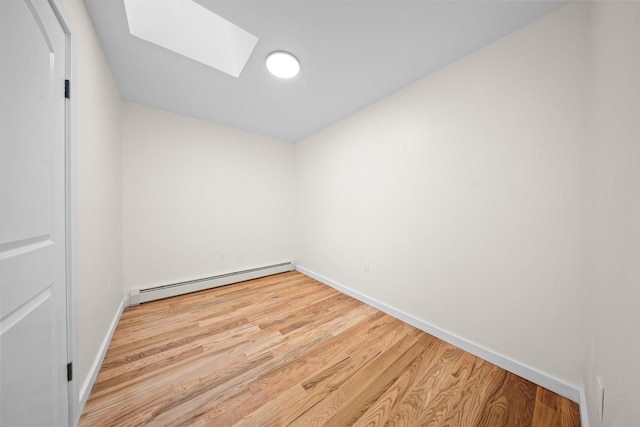 486 Ashford St, Brooklyn, NY 11207 - unfurnished room featuring a baseboard heating unit, a skylight, baseboards, and wood finished floors