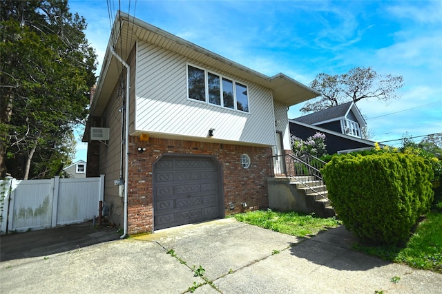 51 Manor Rd, Valley Stream, NY 11580 - view of front of property with a garage, fence, brick siding, and concrete driveway