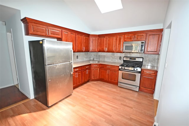 51 Manor Rd, Valley Stream, NY 11580 - kitchen featuring stainless steel appliances, light wood-style flooring, tasteful backsplash, light countertops, and vaulted ceiling