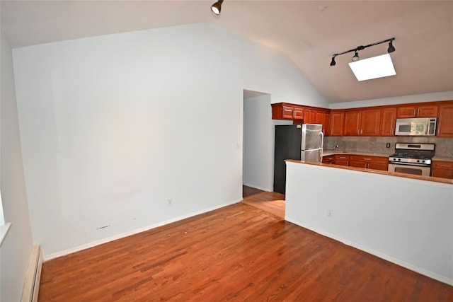 51 Manor Rd, Valley Stream, NY 11580 - kitchen featuring stainless steel appliances, rail lighting, a baseboard heating unit, a skylight, and lofted ceiling