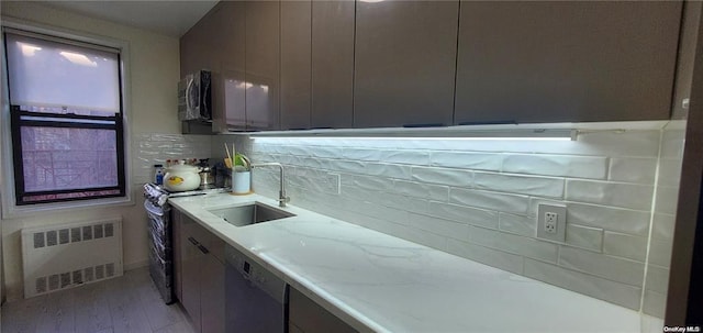 kitchen featuring radiator heating unit, a sink, dishwasher, range with electric cooktop, and backsplash