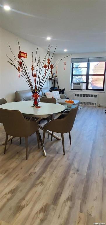 dining room with radiator heating unit and light wood finished floors