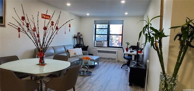 sitting room featuring radiator heating unit, wood finished floors, recessed lighting, and cooling unit