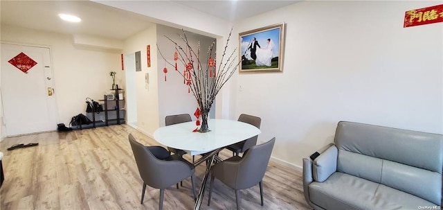 dining space featuring light wood finished floors, baseboards, and recessed lighting