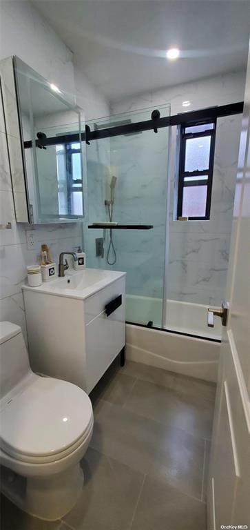 full bath with tile patterned floors, toilet, enclosed tub / shower combo, and vanity