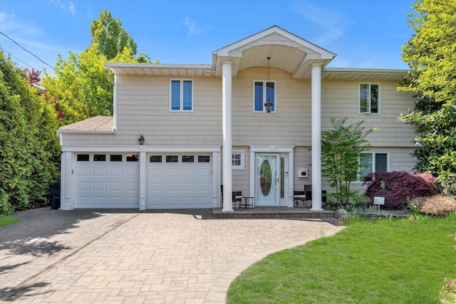 view of front of home featuring decorative driveway and a front yard