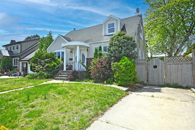 view of front of home with a gate and roof with shingles