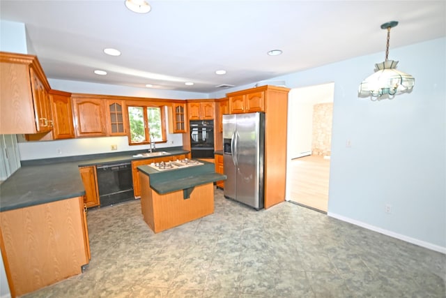 kitchen featuring black appliances, dark countertops, a kitchen island, glass insert cabinets, and brown cabinetry