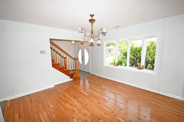 foyer with a chandelier, light wood-type flooring, stairs, and baseboards