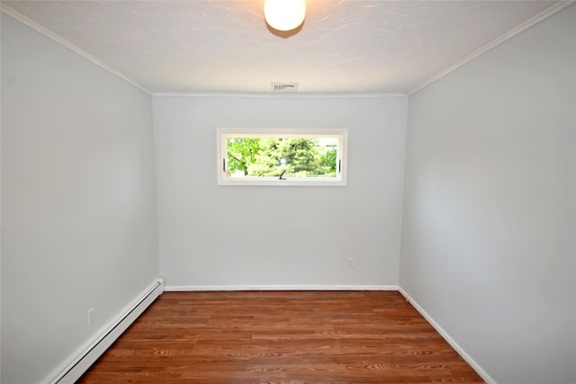 unfurnished room featuring baseboard heating, wood finished floors, ornamental molding, and baseboards
