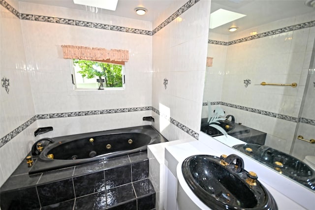 full bath featuring tile walls, a tub with jets, and vanity
