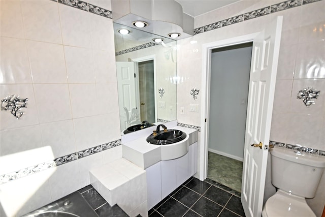 bathroom with tile walls, toilet, tile patterned floors, and vanity