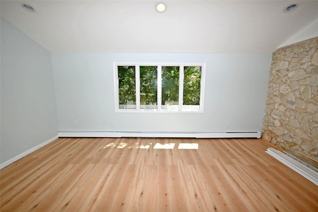 spare room featuring wood finished floors and lofted ceiling