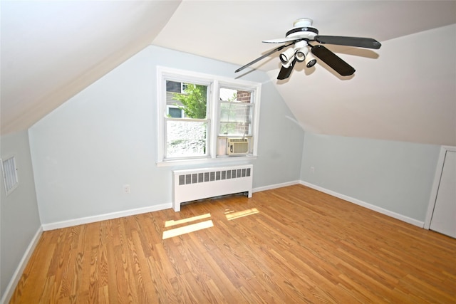 bonus room featuring radiator, light wood-style flooring, baseboards, lofted ceiling, and ceiling fan