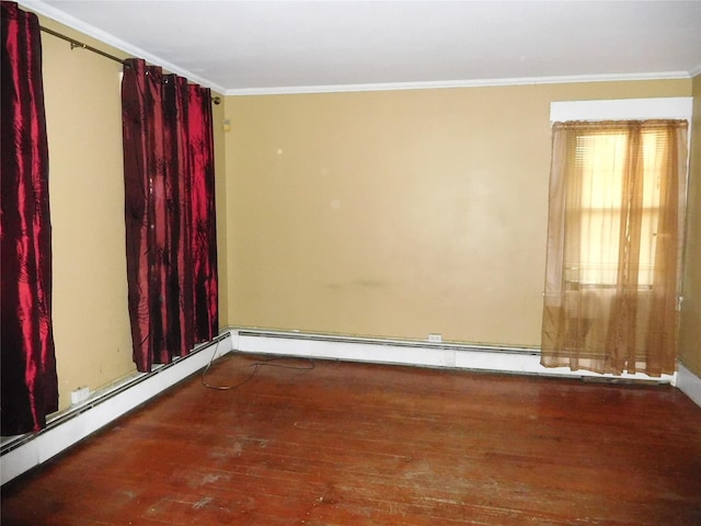 empty room featuring wood finished floors, crown molding, and baseboard heating