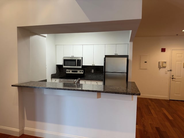 100 New Roc City Pl Unit 408, New Rochelle, NY 10801 - kitchen featuring stainless steel appliances, baseboards, white cabinetry, dark stone countertops, and tasteful backsplash
